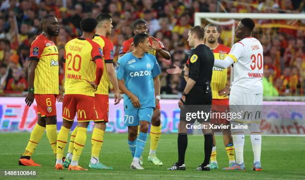 Captain Seko Fofana of Lens react with referee, Clement Turpin and Alexis Sanchez of Marseille during the Ligue 1 match between RC Lens and Olympique...