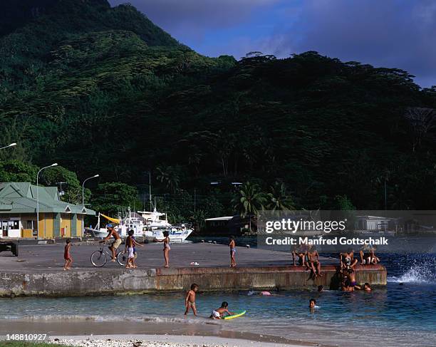 people swimming at the ferry wharf. - huahine photos et images de collection
