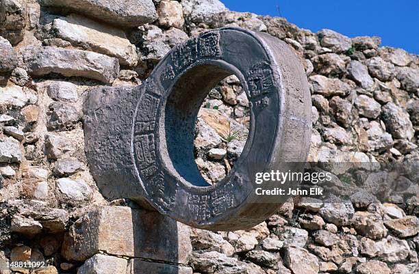 a carved stone ring mounted on a wall of the ball court (juego de pelota) at uxmal, site of mayan ruins. - maya maya stock pictures, royalty-free photos & images