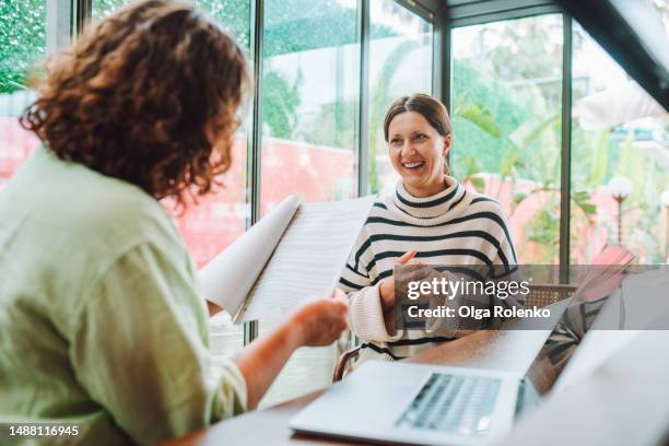 rearview female recruitment reading and checking resume in hands interviewing and hiring woman candidate for joи near laptop in office with glass windows - cv bildbanksfoton och bilder