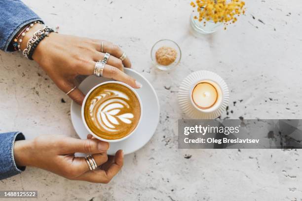 cup of coffee in female hands. cup on white textures stone table surface. - candle overhead stock pictures, royalty-free photos & images