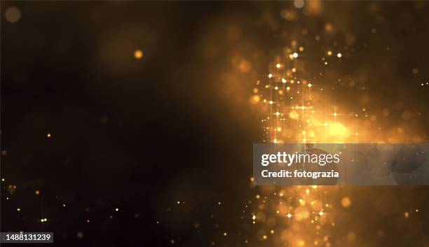 golden blurred particles. copy space - first light awards stock-fotos und bilder