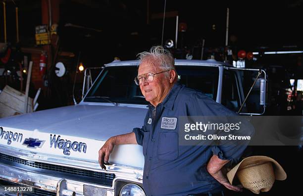 taking a well earned break leaning on a pickup truck, dick's garage has been in business on the old route 66 since 1943. - 1943 stock pictures, royalty-free photos & images