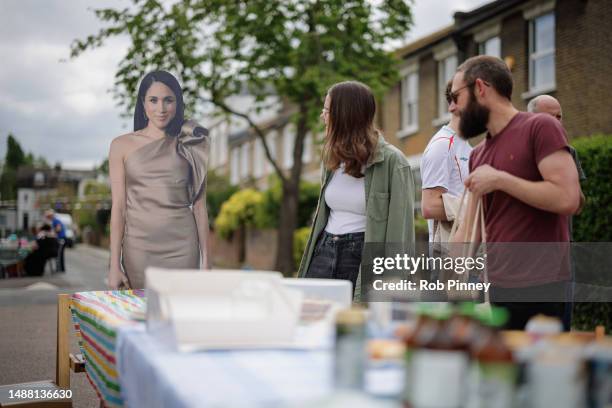 Cardboard cutout of Meghan, Duchess of Sussex stands at the head of the table at a street party on Denman Road to mark the Coronation of King Charles...