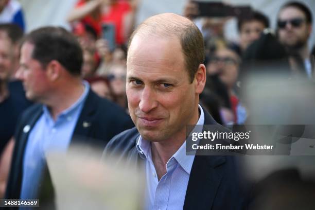 Prince William, Prince of Wales speaks to people during a walkabout at The Big Lunch in Windsor, during the Coronation of King Charles III and Queen...
