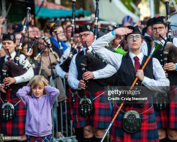 Young girl finds the Pipe Bands sounds fronm their Bagpipes a bit to loud and covers her ears at the Highland Gathering, a two day event of...