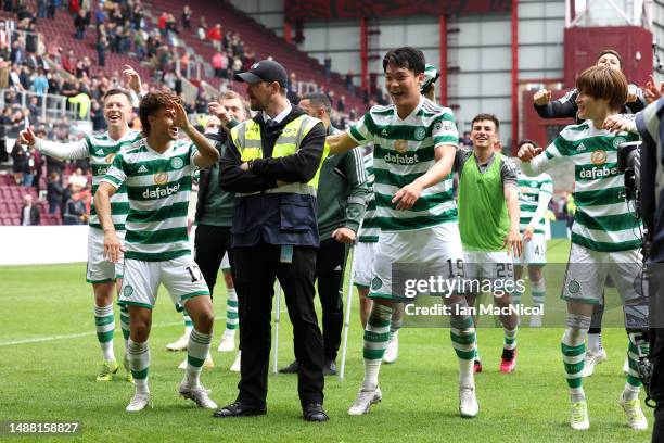 Jota and Oh Hyeon-Gyu of Celtic, celebrate after winning the Cinch Scottish Premiership following the match between Heart of Midlothian and Celtic FC...
