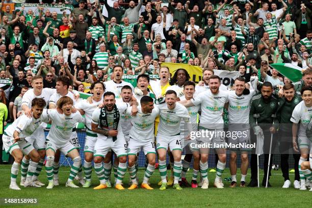 Celtic players celebrate after winning the Cinch Scottish Premiership following the match between Heart of Midlothian and Celtic FC at Tynecastle...