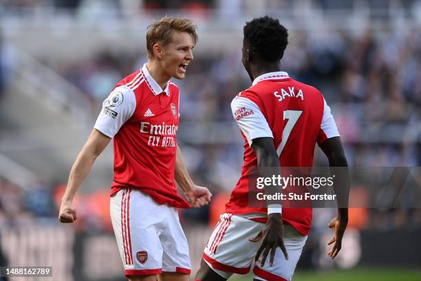 Martin Odegaard of Arsenal celebrates after scoring the team's first goal with teammate Bukayo Saka during the Premier League match between Newcastle...