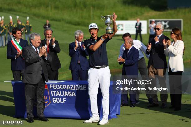 Adrian Meronk of Poland is presented with the trophy on the 18th green by Antonio Tajani, Vice President of the Council and Minister of Foreign...