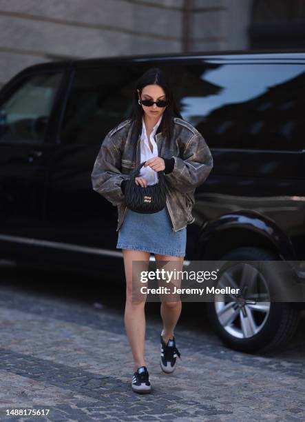 Anna Winter seen wearing Saint Laurent black sunglasses, silver earrings, Filippa K white button shirt, DUCIE London grey faded leather bomber...