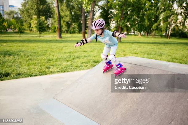 six year old girl on roller skates in park - sports ramp stock pictures, royalty-free photos & images