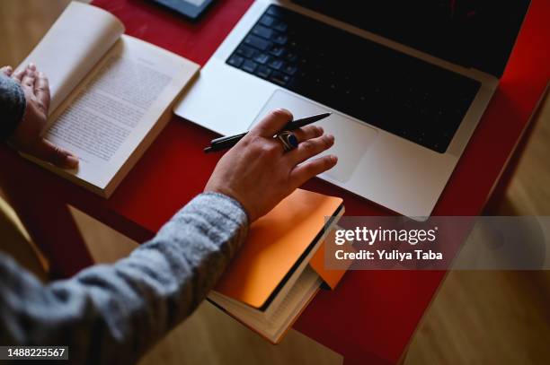 mano della donna che lavora con laptop e libro. - traduzione foto e immagini stock