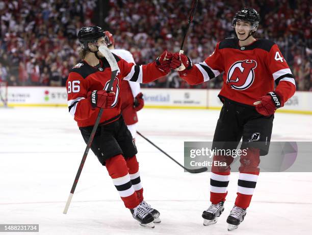 Jack Hughes and Luke Hughes of the New Jersey Devils celebrate teammate Damon Severson's goal during the second period in Game Three of the Second...