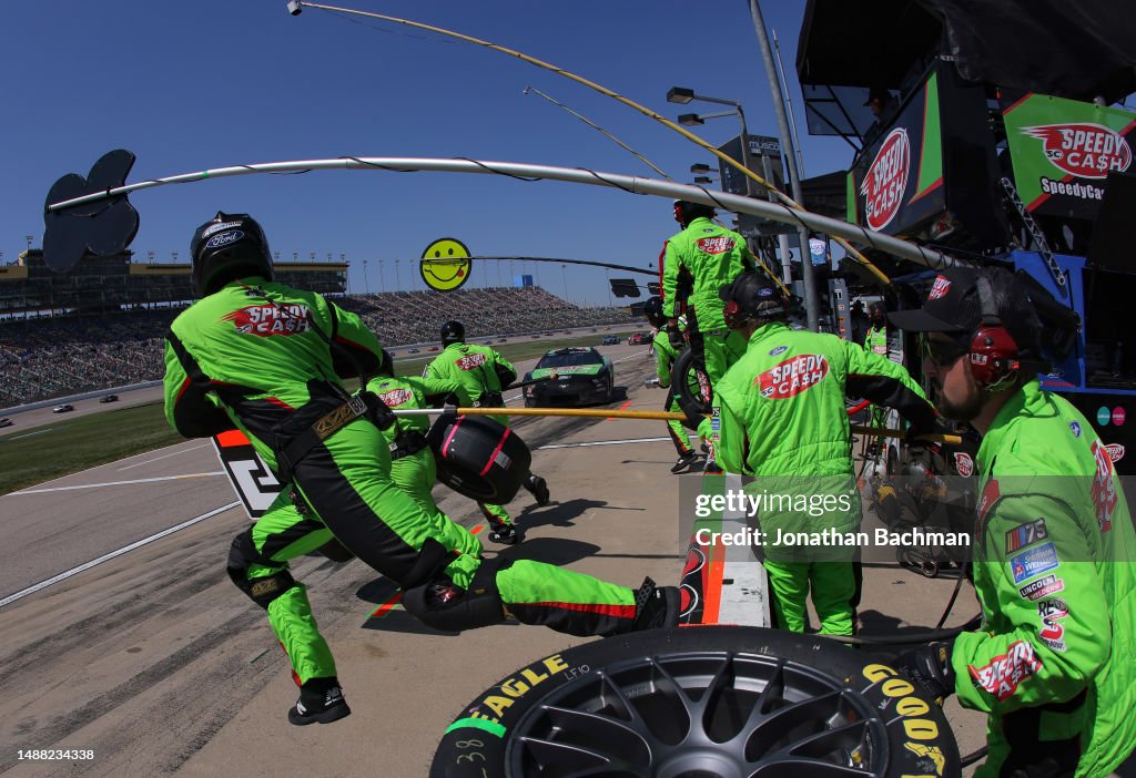 The pit crew of the Speedy Cash Ford, driven by Todd Gilliland leap The pit crew of the Speedy Cash Ford, driven by Todd Gilliland leap