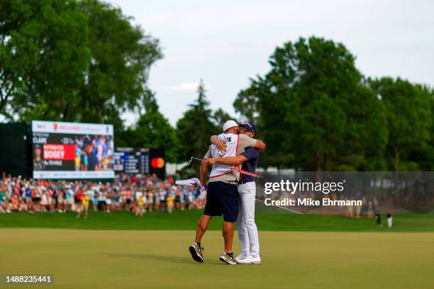 Wyndham Clark of the United States celebrates with his caddie John Ellis after winning on the 18th green during the final round of the Wells Fargo...