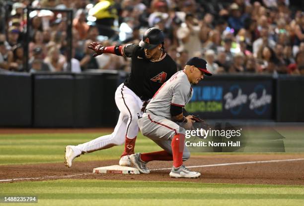 Ketel Marte of the Arizona Diamondbacks slides safely into third base with an RBI triple as Ildemaro Vargas of the Washington Nationals catches the...