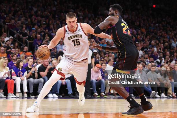 Nikola Jokic of the Denver Nuggets drives the ball past Deandre Ayton of the Phoenix Suns during Game Three of the NBA Western Conference Semifinals...