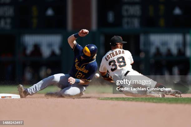 Joey Wiemer of the Milwaukee Brewers steals second base ahead of Thairo Estrada of the San Francisco Giants in the top of the ninth inning at Oracle...