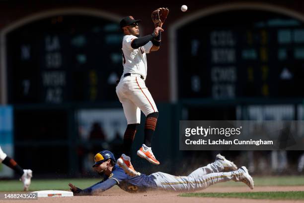 Christian Yelich of the Milwaukee Brewers steals second base ahead of a tag by Thairo Estrada of the San Francisco Giants in the top of the ninth...