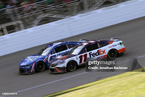 Denny Hamlin, driver of the FedEx Express Toyota, and Kyle Larson, driver of the HendrickCars.com Chevrolet, race during the NASCAR Cup Series Advent...