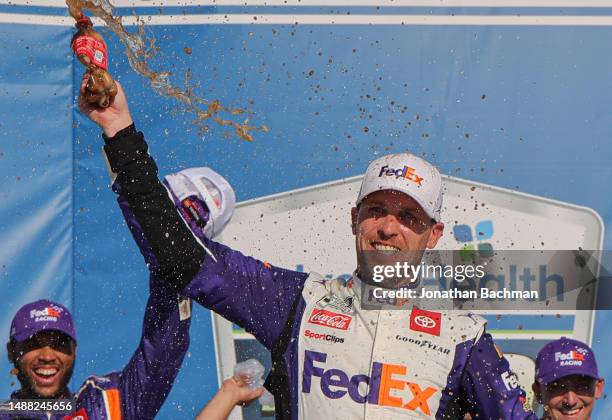 Denny Hamlin, driver of the FedEx Express Toyota, celebrates in victory lane after winning the NASCAR Cup Series Advent Health 400 at Kansas Speedway...