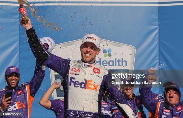 Denny Hamlin, driver of the FedEx Express Toyota, celebrates in victory lane after winning the NASCAR Cup Series Advent Health 400 at Kansas Speedway...