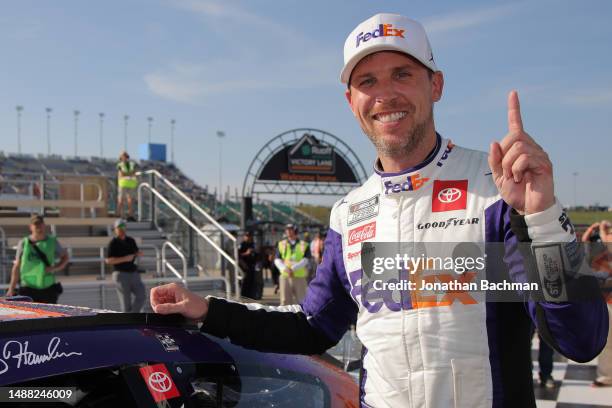 Denny Hamlin, driver of the FedEx Express Toyota, poses next to his winner sticker in victory lane after winning the NASCAR Cup Series Advent Health...