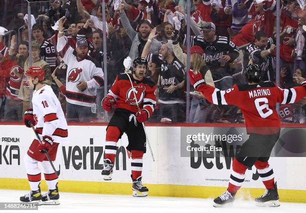 Miles Wood of the New Jersey Devils celebrates his goal with teammate John Marino during the third period as Jack Drury of the Carolina Hurricanes...