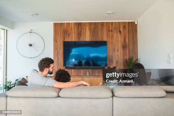 bright living room with stylish clock and entertainment center - kids watching tv no adult stock pictures, royalty-free photos & images