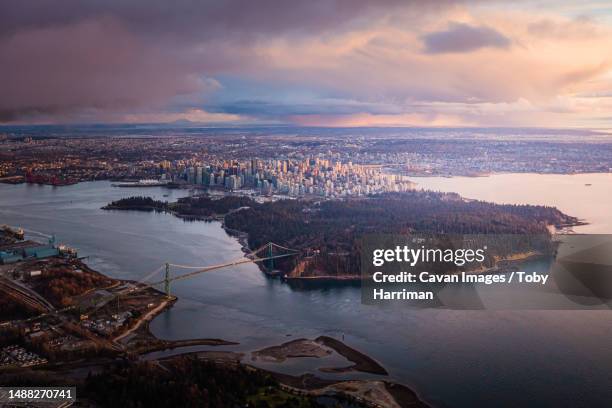 vancouver skyline lions gate bridge aerial sunset glow - vancouver lions gate stock pictures, royalty-free photos & images