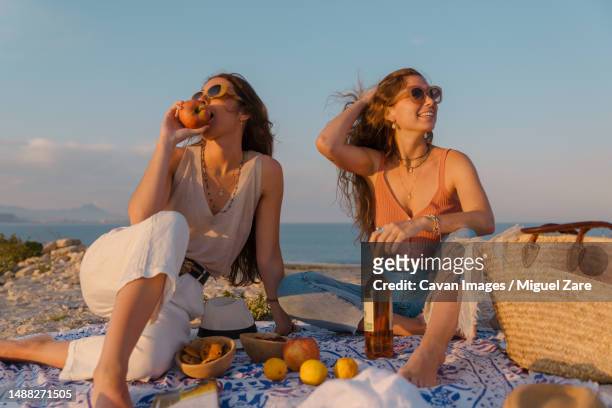 young girls couple travel summer vacation - woman stretching sunset stock-fotos und bilder