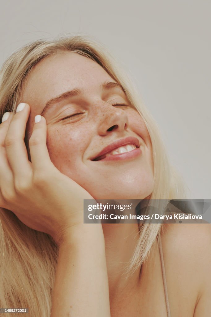 Freckles blonde blue-eyed woman, perfect skin smiling