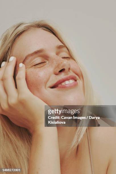 freckles blonde blue-eyed woman, perfect skin smiling - beauty treatment stock pictures, royalty-free photos & images