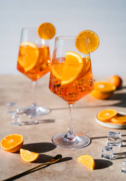 close up of two spritz drinks on sunny beige background - orange cocktail stock pictures, royalty-free photos & images