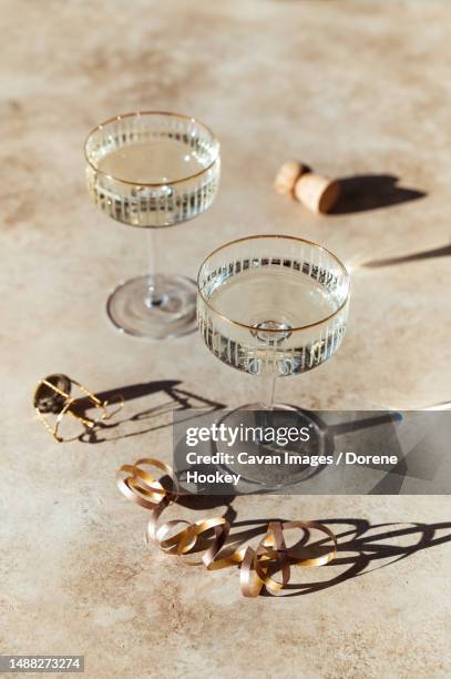 close up of two glasses of champagne on sunny beige background - glass of prosecco stockfoto's en -beelden