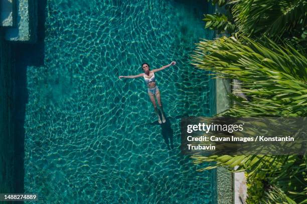 aerial view of woman in pool - floating on water stock pictures, royalty-free photos & images
