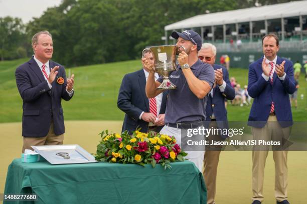 Wyndham Clark of the United States is presented with the trophy on the 18th hole after his win during the Final Round at the Wells Fargo Championship...