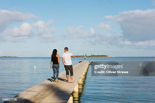 young couple walking out on jetty next to hotel royal tera. - grande terre nueva caledonia fotografías e imágenes de stock