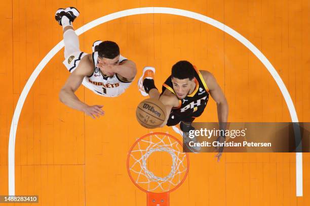 Devin Booker of the Phoenix Suns lays up a shot past Michael Porter Jr. #1 of the Denver Nuggets during the first half of Game Four of the NBA...