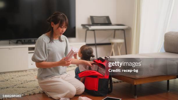 woman preparing emergency bag at home - evacuation plan stock pictures, royalty-free photos & images