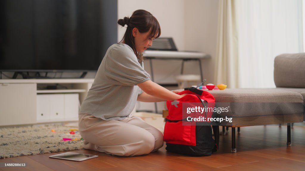 Woman preparing emergency bag at home