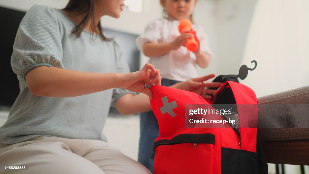 Mujer preparando bolsa de emergencia en casa