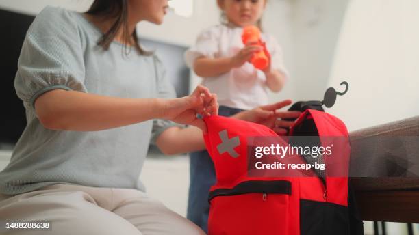 mujer preparando bolsa de emergencia en casa - huracán fotografías e imágenes de stock