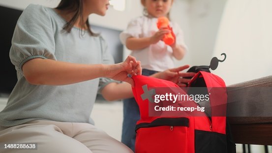 Mulher que prepara bolsa de emergência em casa Mulher que prepara bolsa de emergência em casa