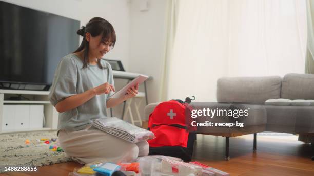 woman preparing emergency bag at home - kit stockfoto's en -beelden