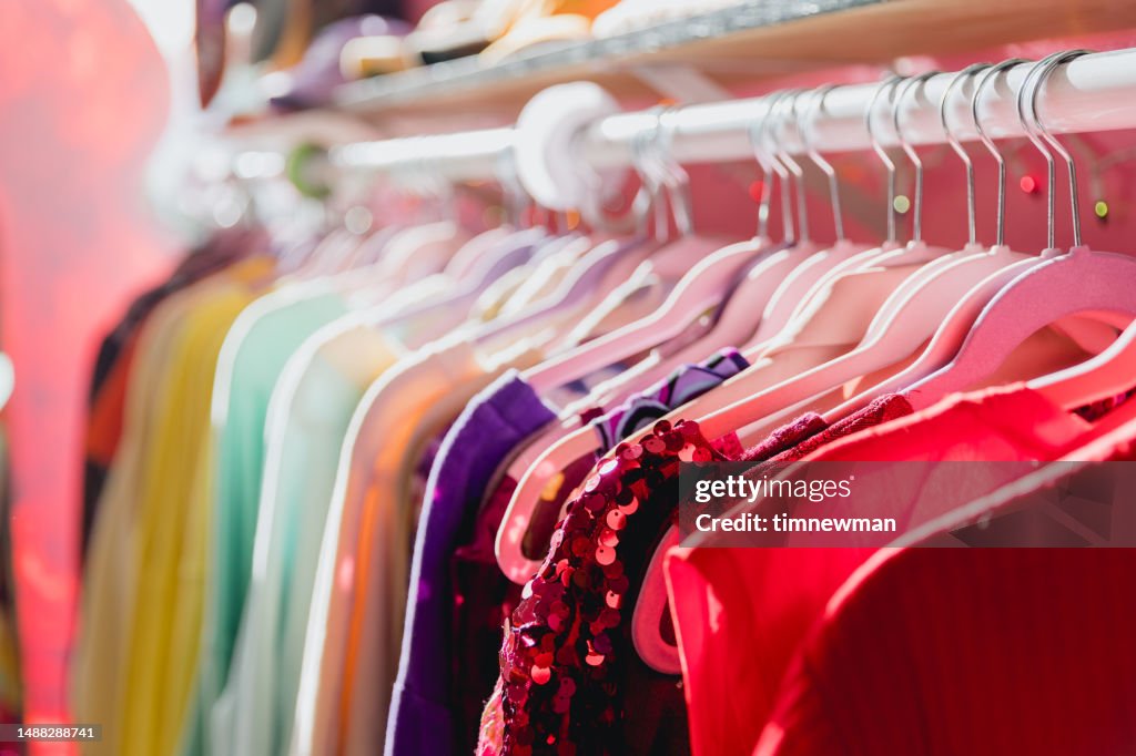 Bunter, lebendiger Kleiderständer in einem Secondhand-Laden