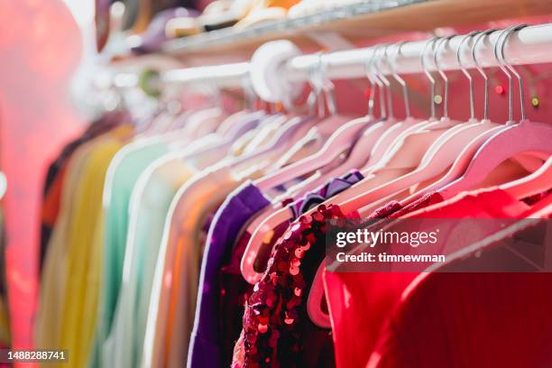 rack de roupas vibrantes coloridas em um brechó - coathanger - fotografias e filmes do acervo