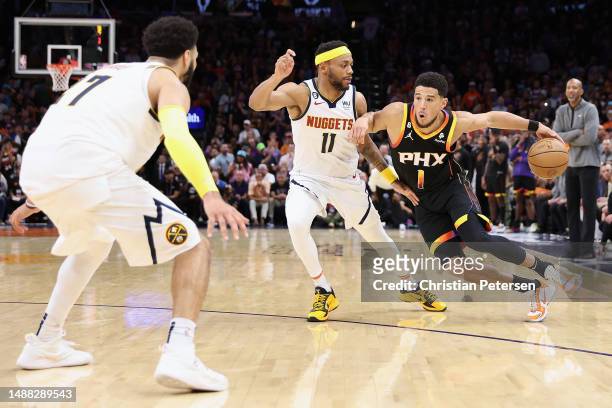 Devin Booker of the Phoenix Suns handles the ball against Bruce Brown of the Denver Nuggets during the second half of Game Four of the NBA Western...