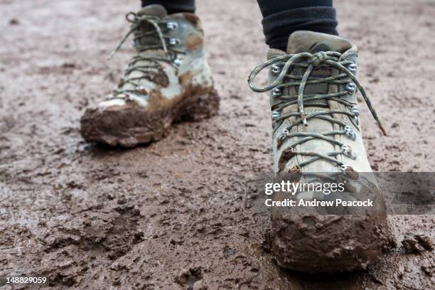 muddy boots at base of mweka trail after a descent of mount kilimanjaro. - lodo fotografías e imágenes de stock